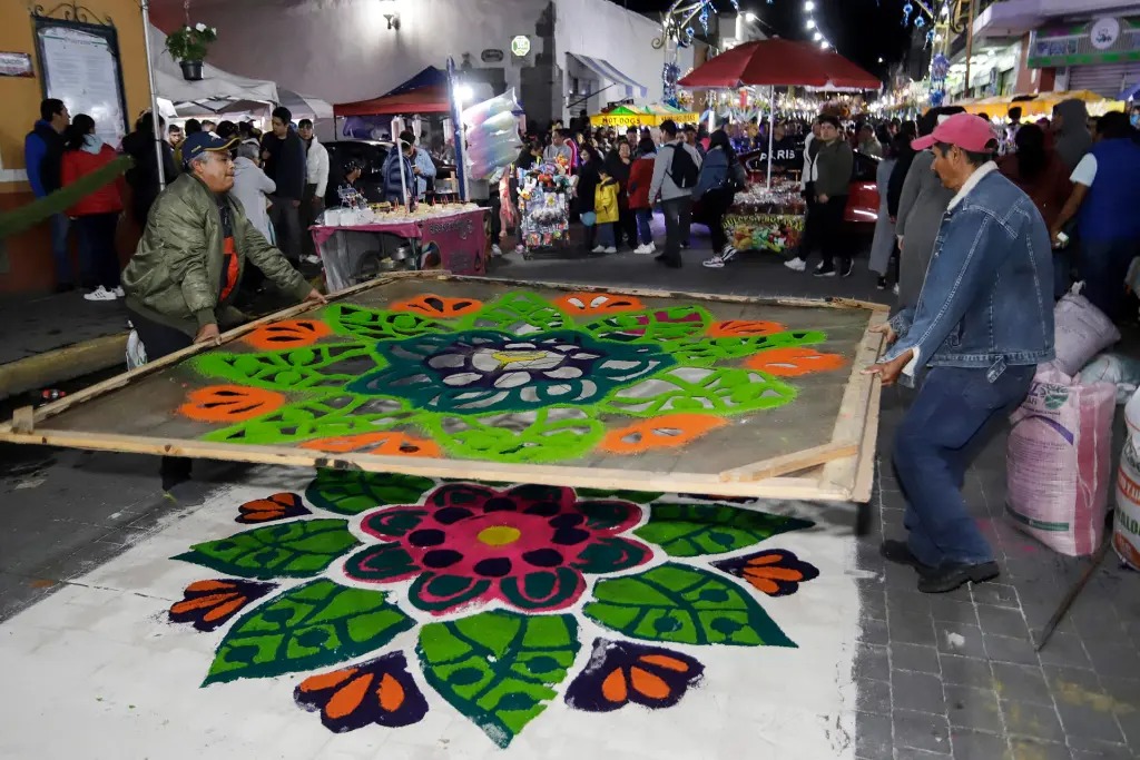 Tapetes monumentales de aserrín de colores de hasta 100 metros de largo realizados por artesanos se desplegaron en una ruta de 7 kilómetros que simboliza el paso de la Virgen de la Caridad en las calles de Huamantla, municipio de Tlaxcala.