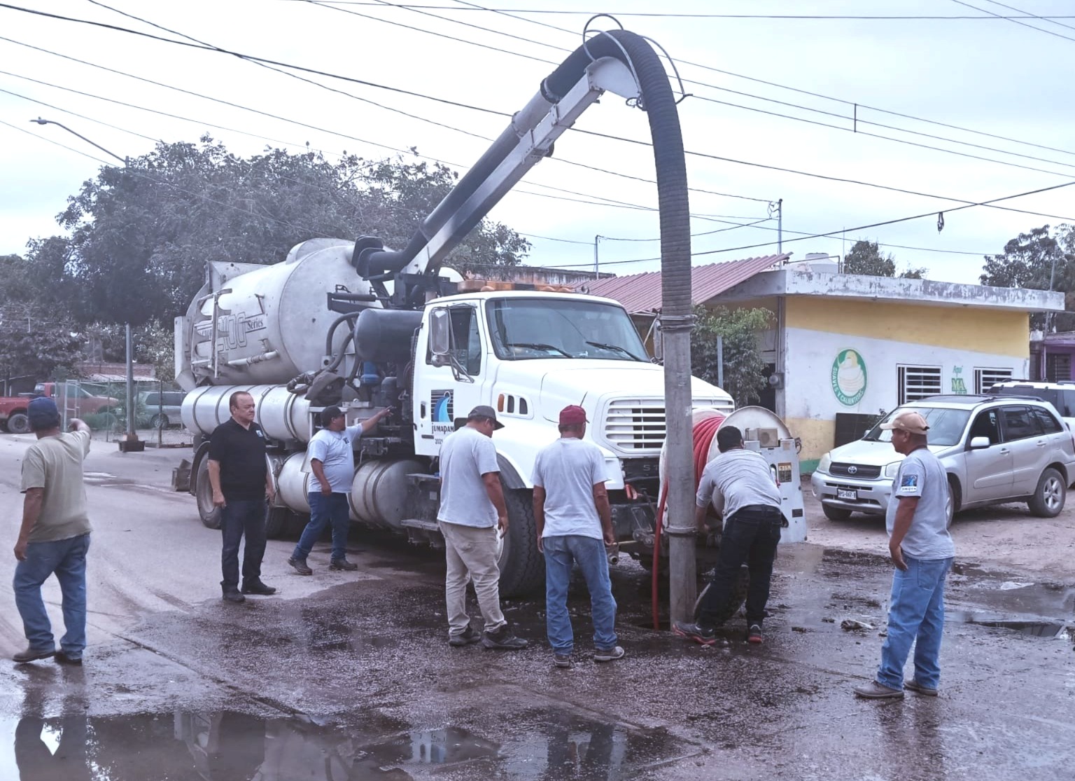 Extrae basura y grasas que estaban causando un derrame de aguas residuales en varias calles del asentamiento